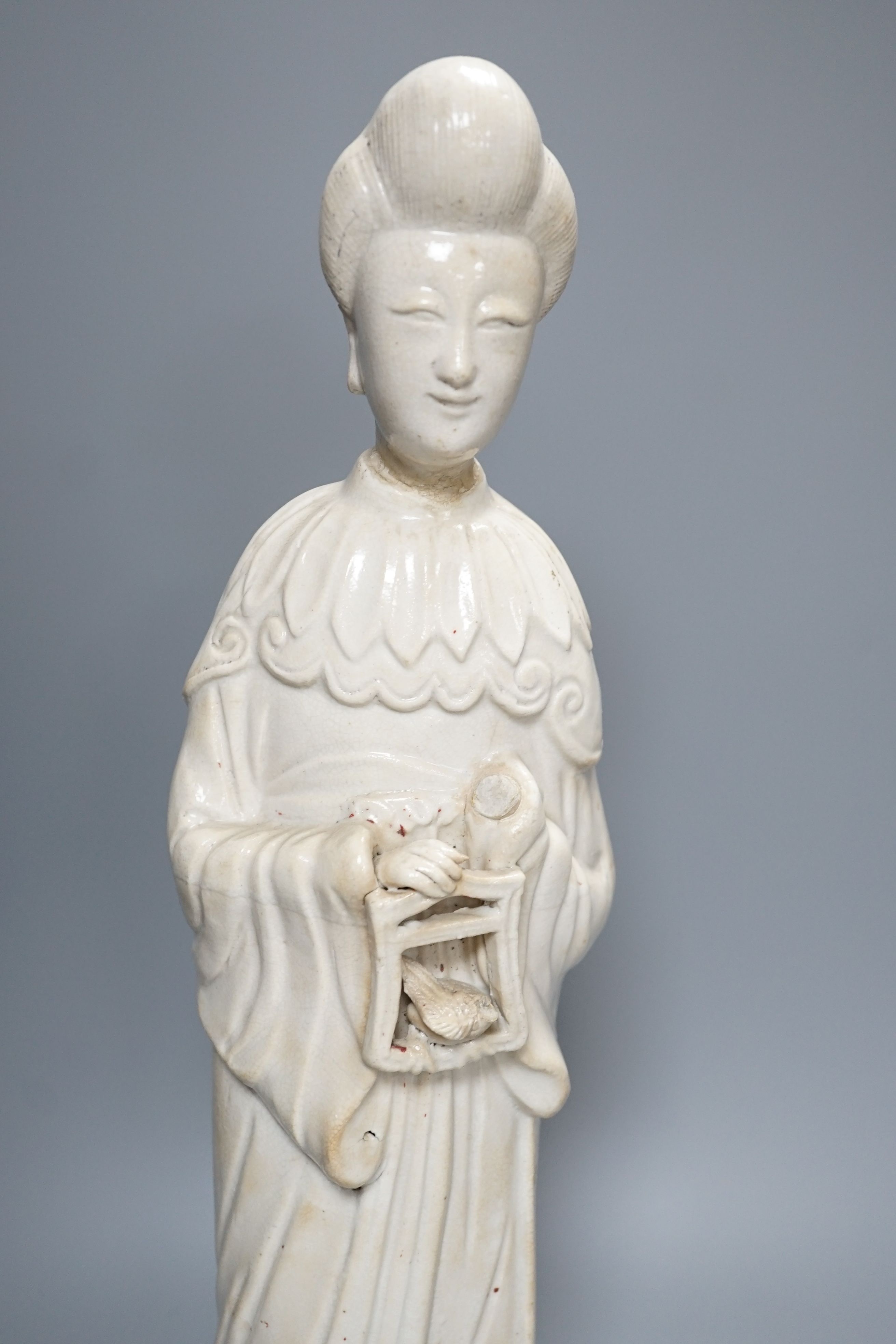A Chinese blanc de chin figure of a lady with a bird, 37cm, together with a famille rose teapot, a yixing style teapot, blue and white jar and cover and a pale celadon ground ‘ox head’ libation cup